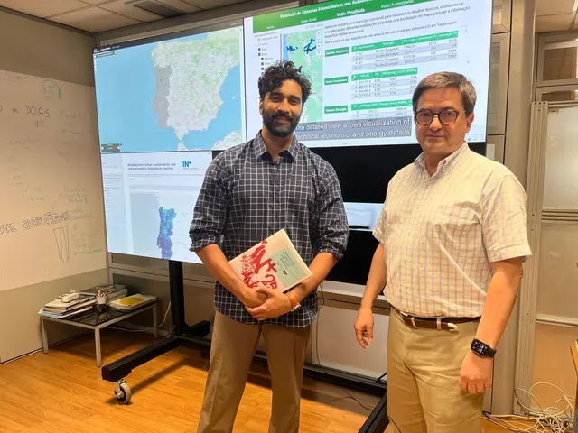 Two people beside displays showing maps and solar energy data.