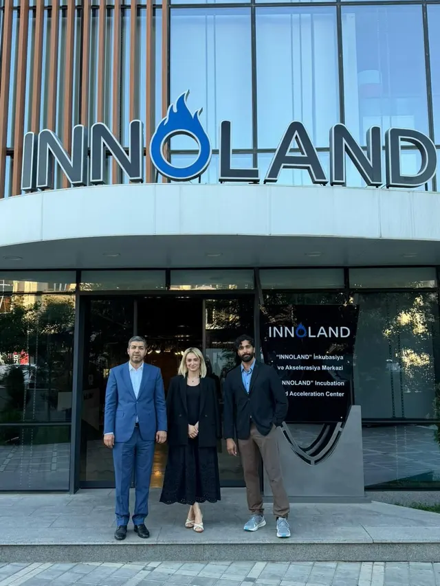Three people standing outside the INNOLAND incubation and acceleration centre.