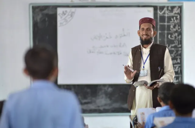Teacher at a whiteboard while students watch